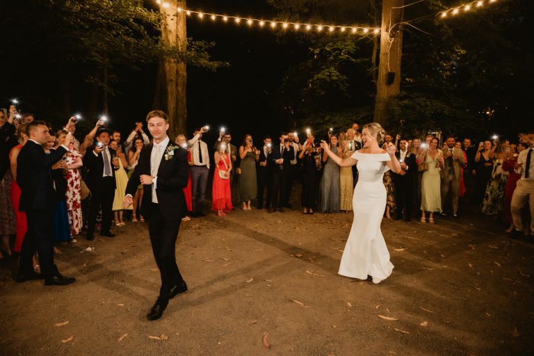 Energetic and joyful moment as the bride and groom make their grand entrance to the wedding dinner at Tinakilly Country House in Ireland. Guests cheer, creating an unforgettable party atmosphere. This fine art wedding photograph captures celebration, excitement, and the couple’s happiness. Photographed by WeddingWithMe, it highlights professional wedding photography and videography, perfect for Irish wedding galleries, social media, and SEO-optimized luxury wedding website content