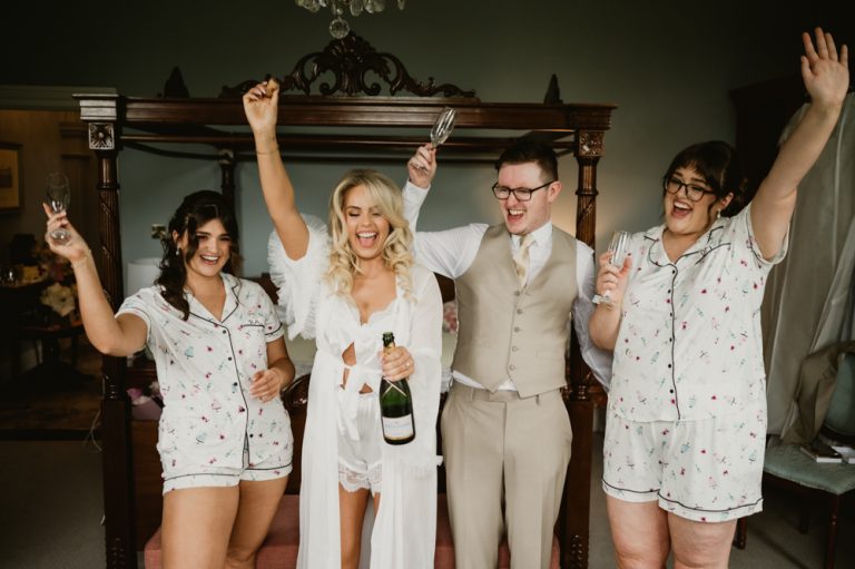 Bridesmaids toasting with champagne and popping corks at Killashee Manor House – Irish wedding photography, Bridgerton inspired wedding