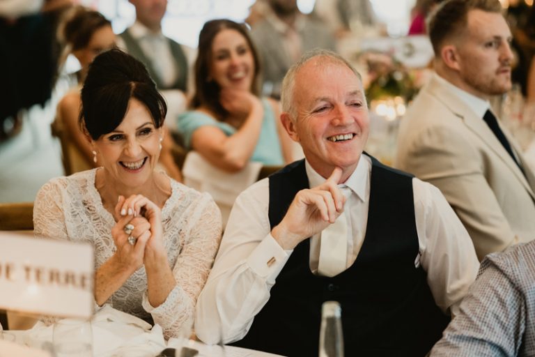 Parents smiling during emotional wedding speech at reception in Ballykealey House captured by WeddingWithMe in Ireland