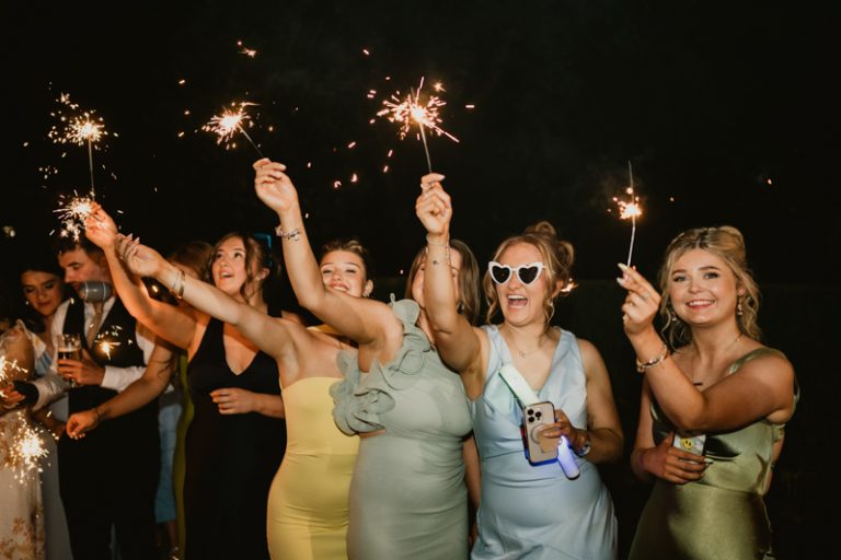 Couple walking through sparklers at night during wedding exit at Ballykealey House captured by WeddingWithMe in Ireland